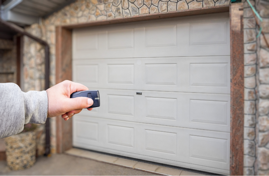 Hand pressing remote to open closed garage